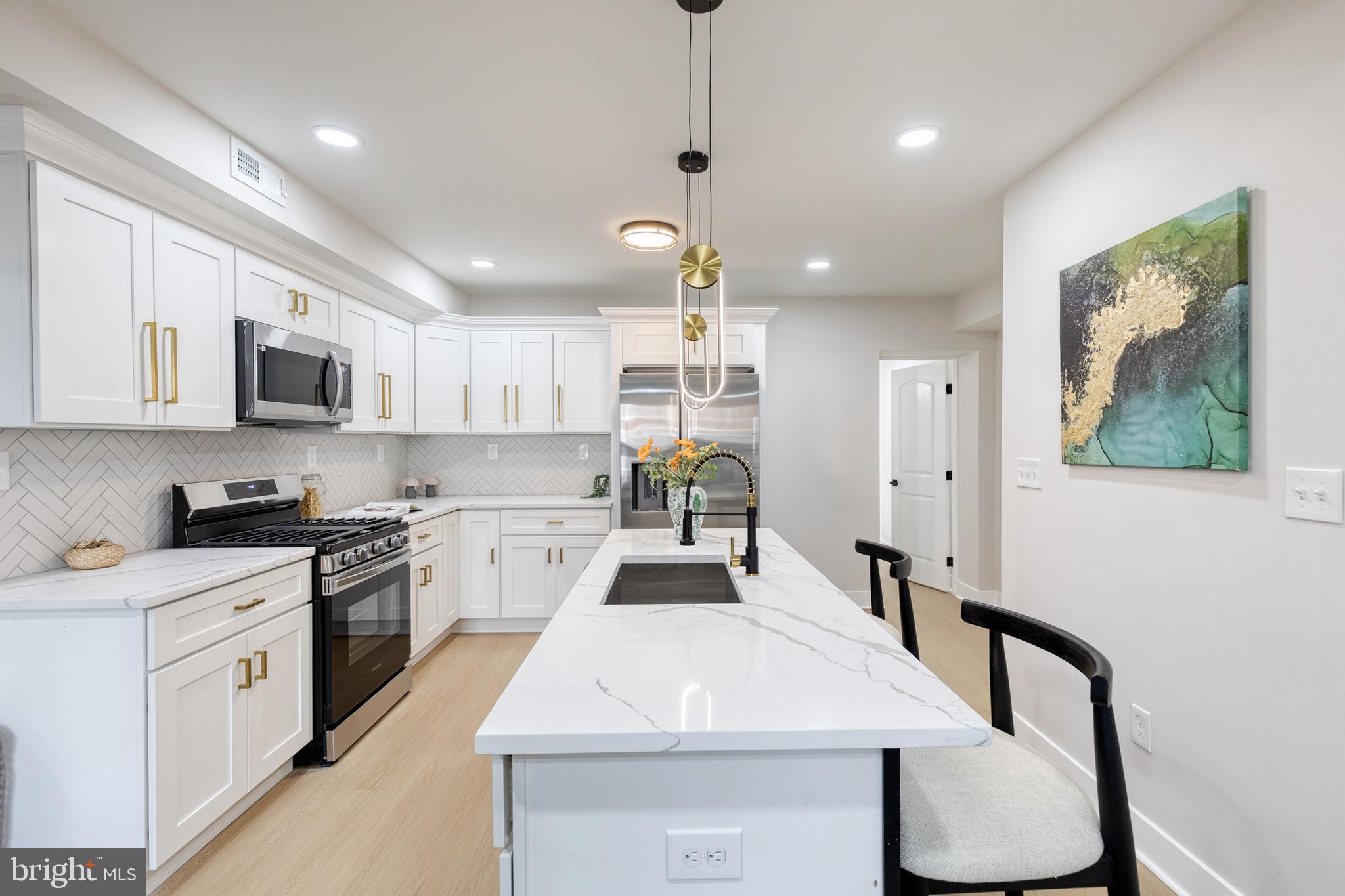 3721 Manchester Avenue Baltimore, MD 21215 - Photo 12 of 36 a kitchen with kitchen island a stove a table and chairs in it