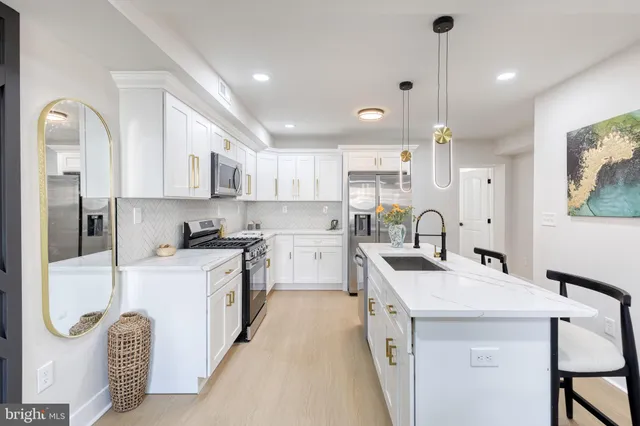 a kitchen with white cabinets and refrigerator