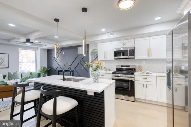 a kitchen with stainless steel appliances granite countertop a stove a sink a microwave a refrigerator with a dining table and chairs