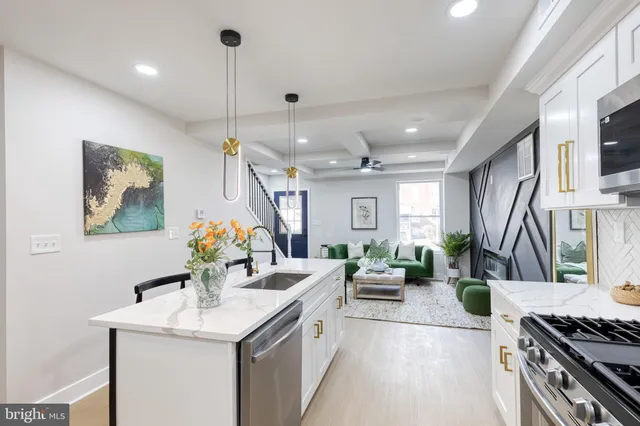 a kitchen with stainless steel appliances kitchen island granite countertop a sink a stove and a wooden floors