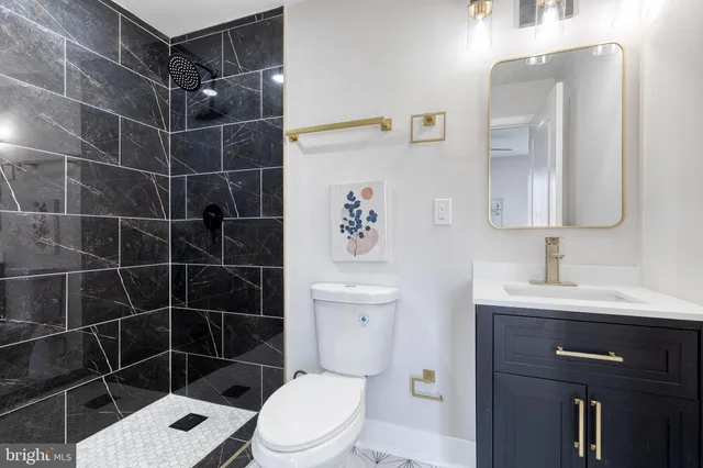 a bathroom with a toilet a sink a mirror and vanity