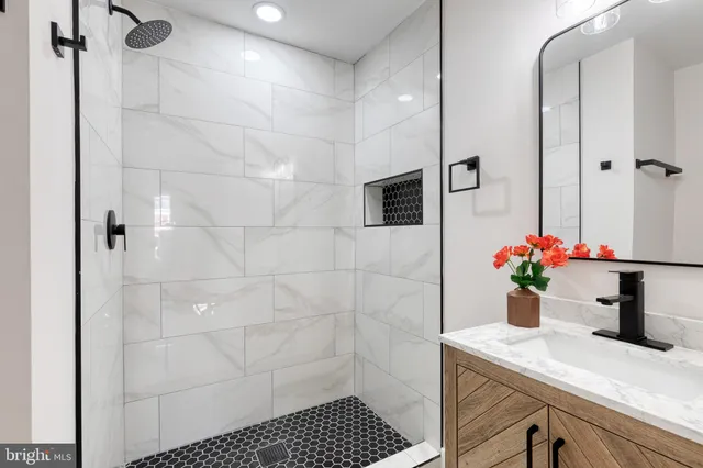 a bathroom with a sink a potted plant and a shower