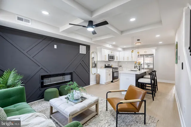 a living room with furniture kitchen view and a potted plant
