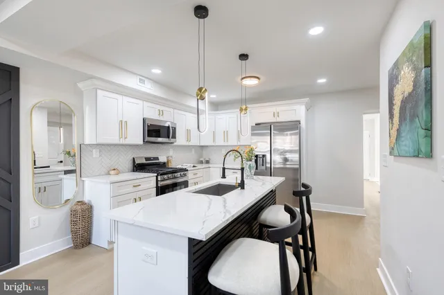 a kitchen with granite countertop a sink a stove a refrigerator a stove a dining table and chairs