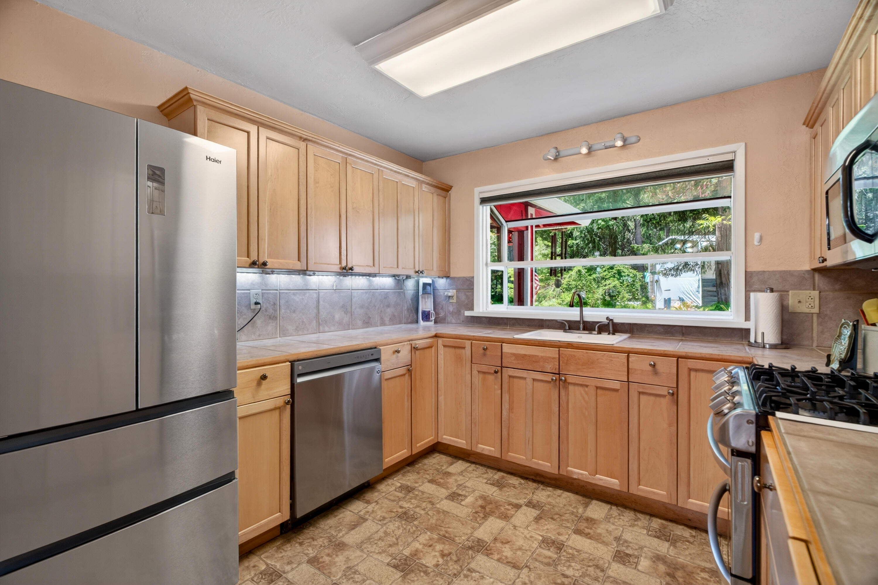 8015 Starlite Pines Road Shingletown, CA 96088 - Photo 13 of 38 a kitchen with stainless steel appliances granite countertop a refrigerator a sink dishwasher a stove and white countertops with wooden floor