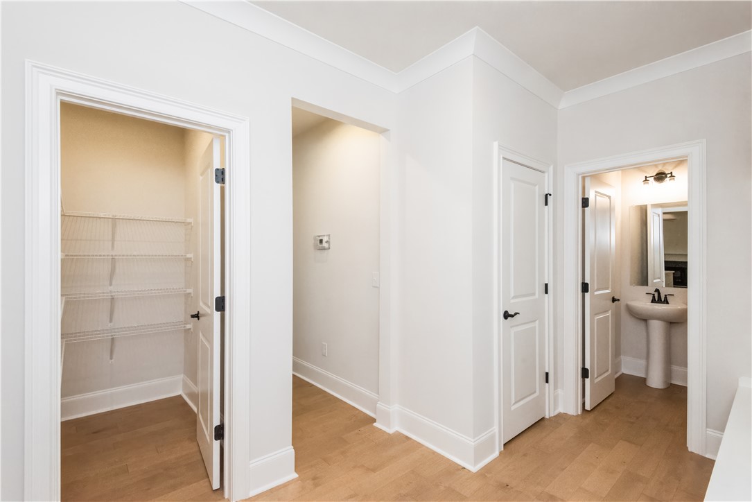 222 Holly Br Road Piedmont, SC 29673 - Photo 19 of 31 This interior hallway features warm flooring and crown molding, leading to a closet and bathroom.