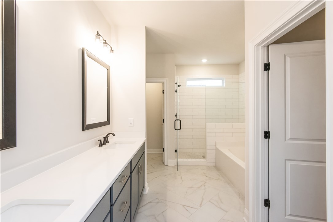 222 Holly Br Road Piedmont, SC 29673 - Photo 22 of 31 This spacious bathroom offers a double vanity, a glass-enclosed shower, and a pristine soaking tub.