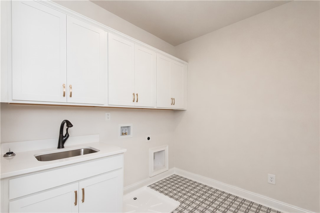 222 Holly Br Road Piedmont, SC 29673 - Photo 29 of 31 Bright laundry room features ample storage, a utility sink, and stylish patterned flooring.