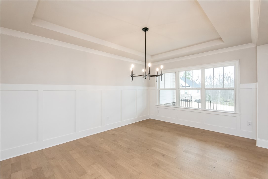 222 Holly Br Road Piedmont, SC 29673 - Photo 6 of 31 This bright space features a striking chandelier and durable hardwood flooring.