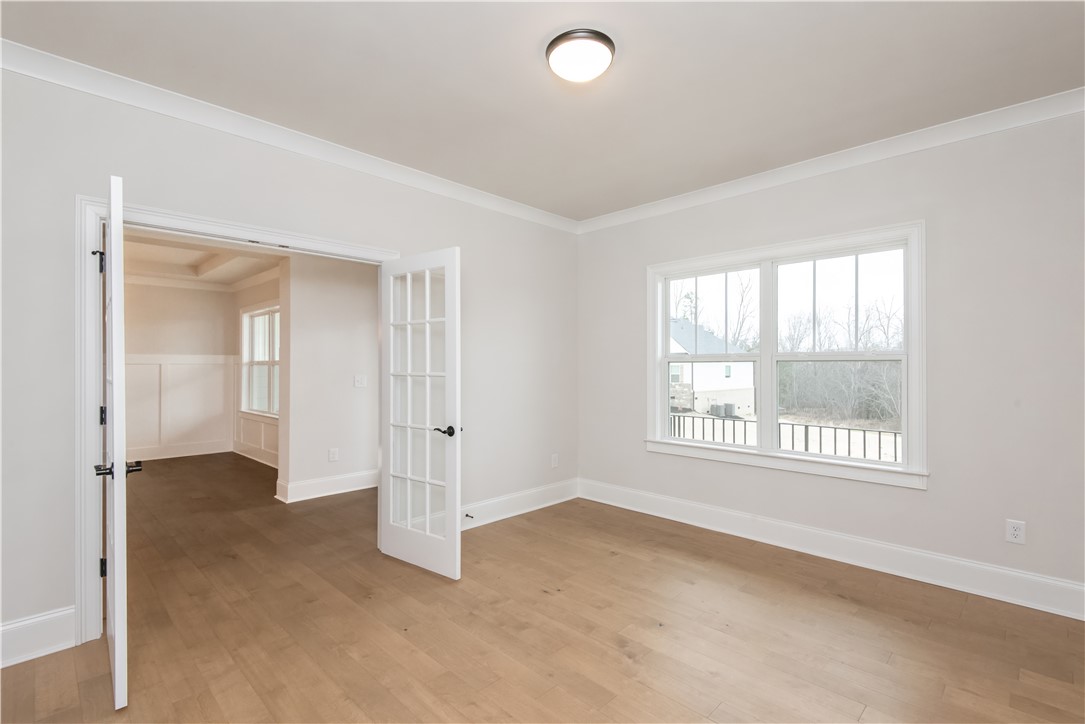 222 Holly Br Road Piedmont, SC 29673 - Photo 7 of 31 This bright room features beautiful hardwood floors and French doors, offering versatile living options.