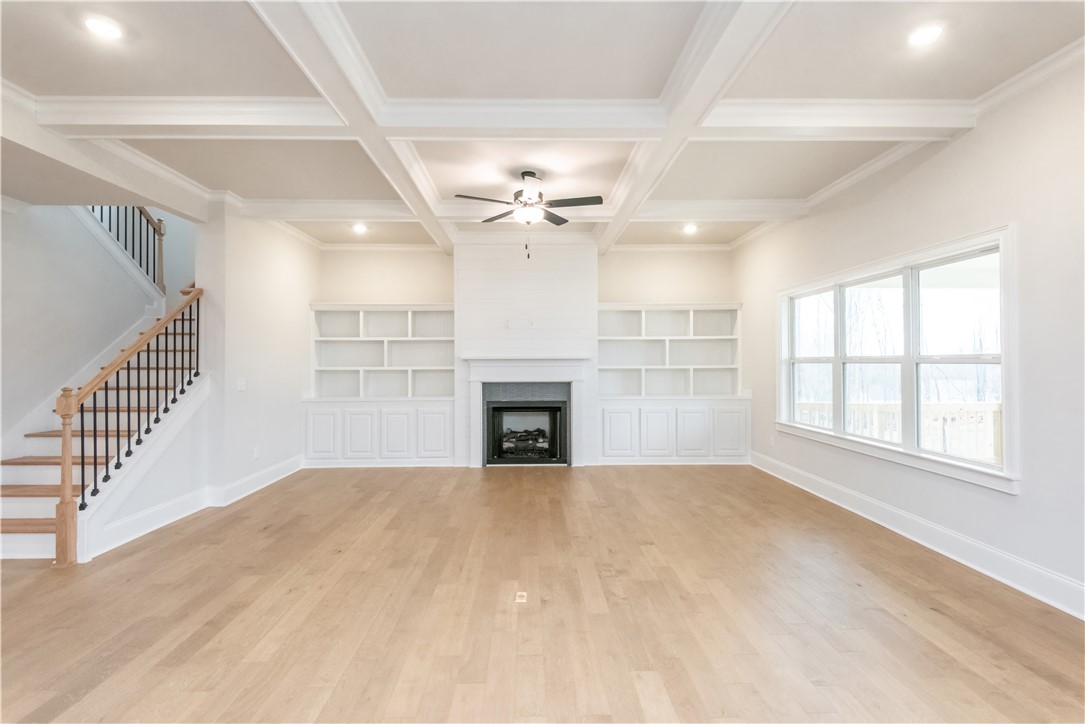 222 Holly Br Road Piedmont, SC 29673 - Photo 9 of 31 This expansive living area features elegant coffered ceilings and built-in shelving, perfect for curated displays.