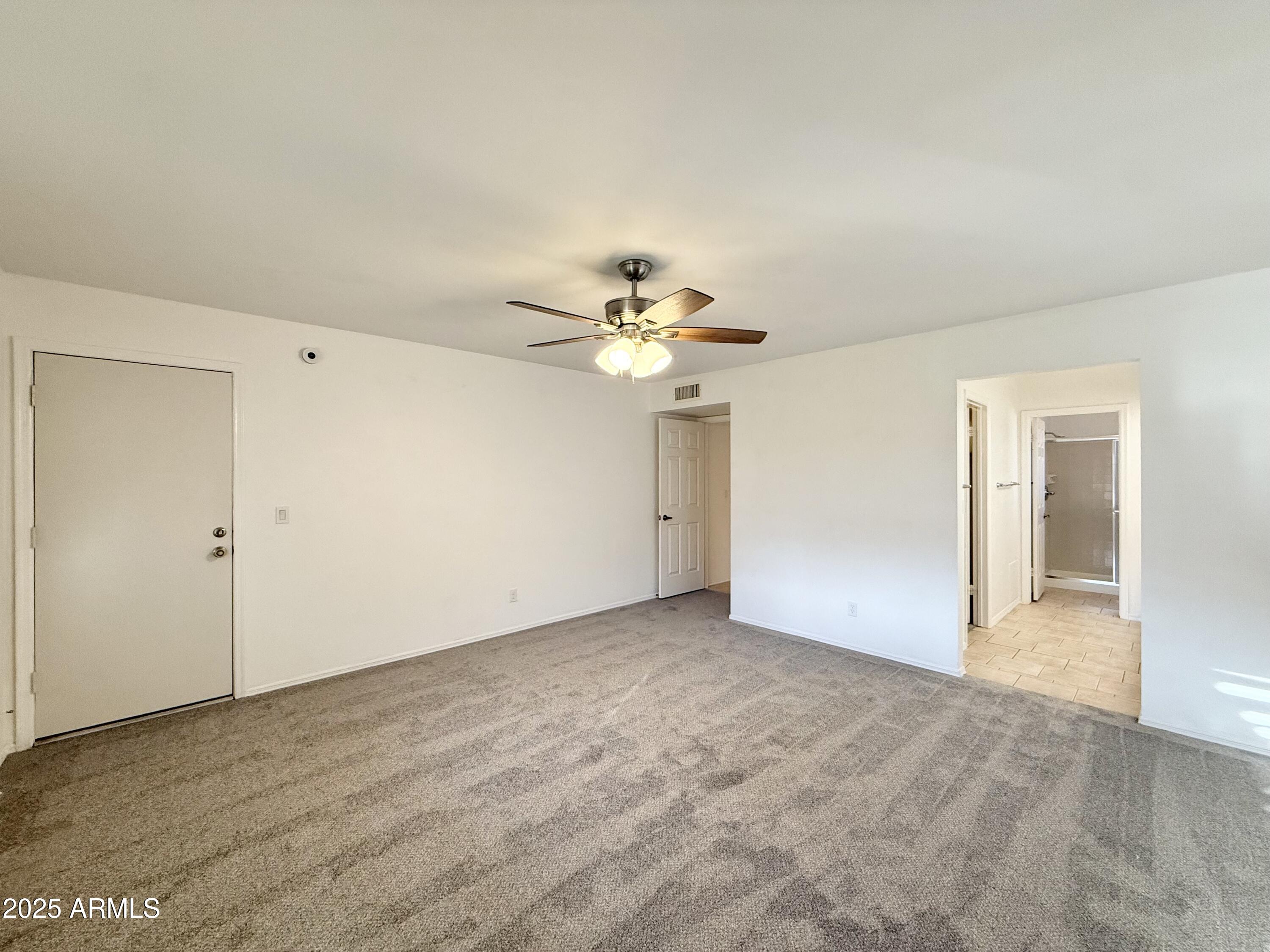 7641 East Pueblo Avenue Mesa, AZ 85208 - Photo 11 of 20 an empty room with closet and a chandelier fan
