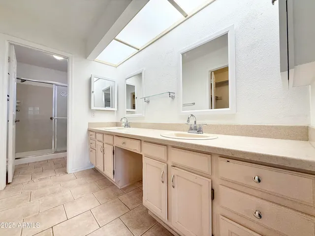 a spacious bathroom with a shower sink and mirror