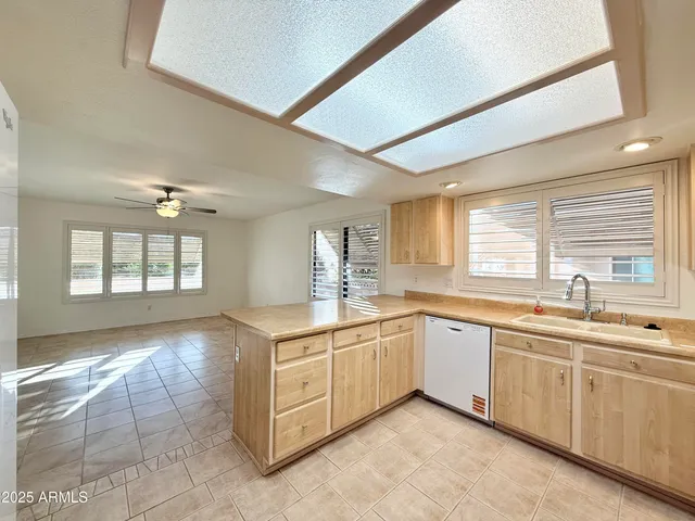 a large white kitchen with a sink and dishwasher with a fireplace