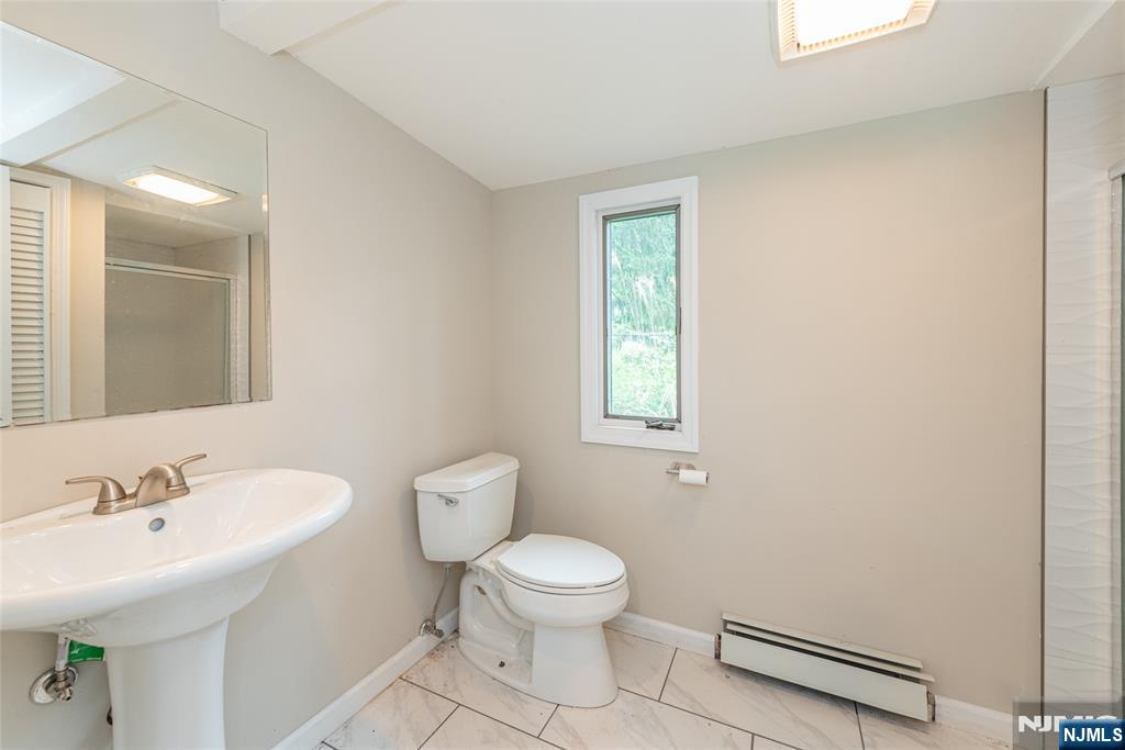 163 Sand Spring Road Morristown, NJ 07960 - Photo 18 of 39 a bathroom with a toilet a sink and a window