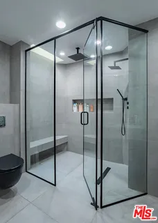 a bathroom with a glass shower door and a shower