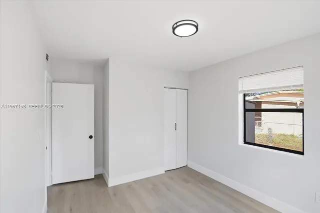 a view of house with backyard and trees in the background