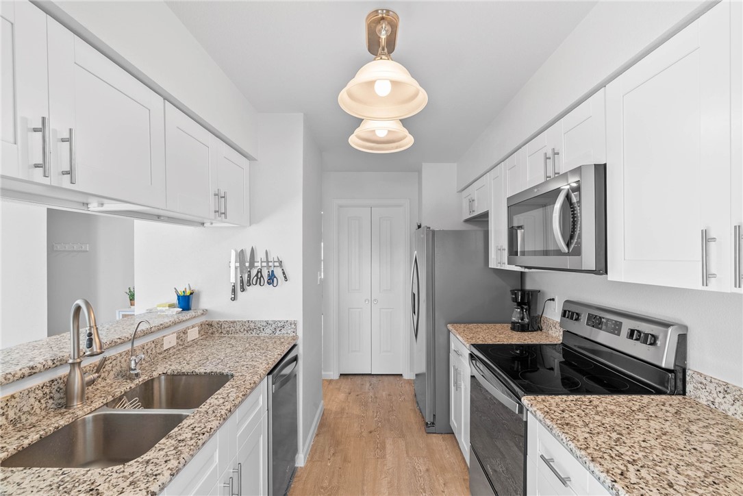 620 South Fulton Beach Road, Unit 611 Rockport, TX 78382 - Photo 8 of 15 a kitchen with stainless steel appliances granite countertop a sink dishwasher stove and refrigerator