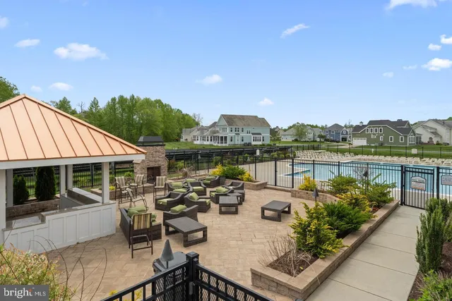 a view of a patio with couches table and chairs under an umbrella