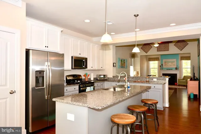 a kitchen with stainless steel appliances granite countertop a sink a stove and a refrigerator