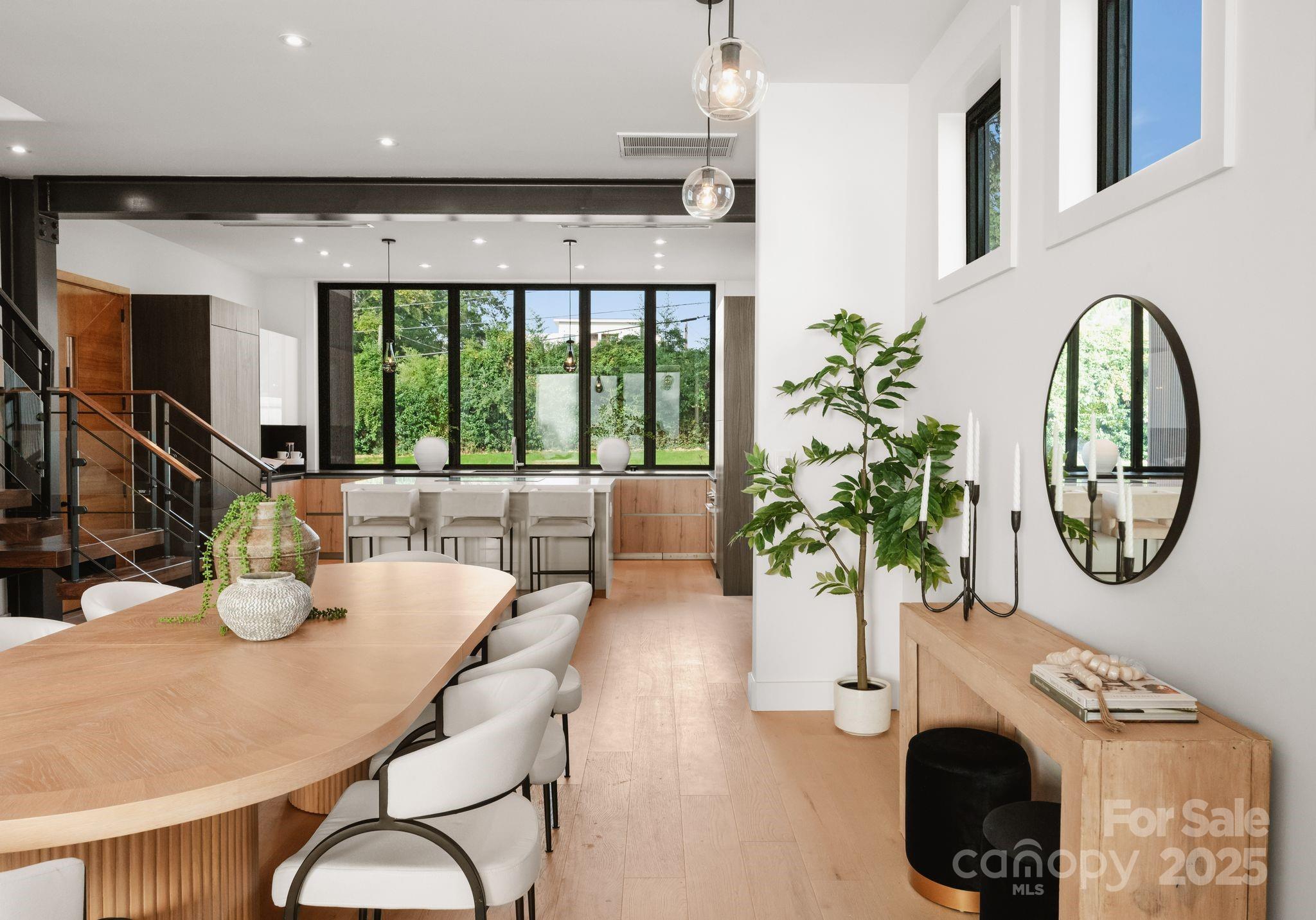 421 Marsh Road, Unit 103 Charlotte, NC 28209 - Photo 12 of 16 a dining room with furniture potted plants and wooden floor