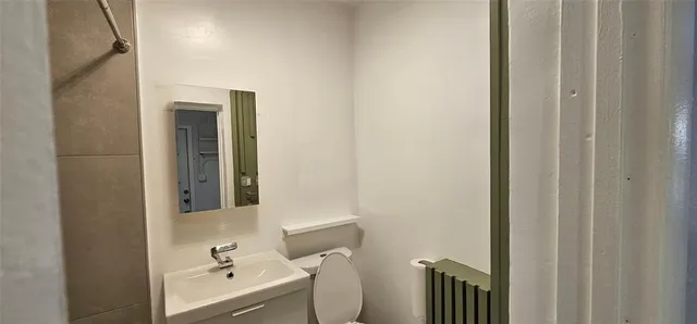 a bathroom with a sink and mirror with toilet