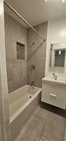 a bathroom with a tub a sink and mirror