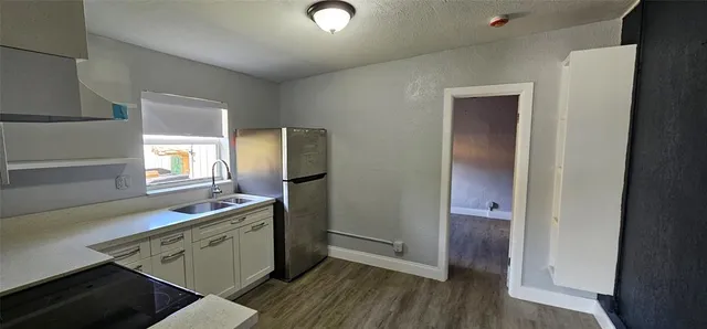 a kitchen with a sink cabinets and wooden floor