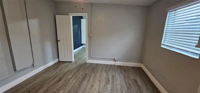 a view of a room with wooden floor and a window