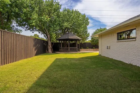 a view of a house with backyard and sitting area