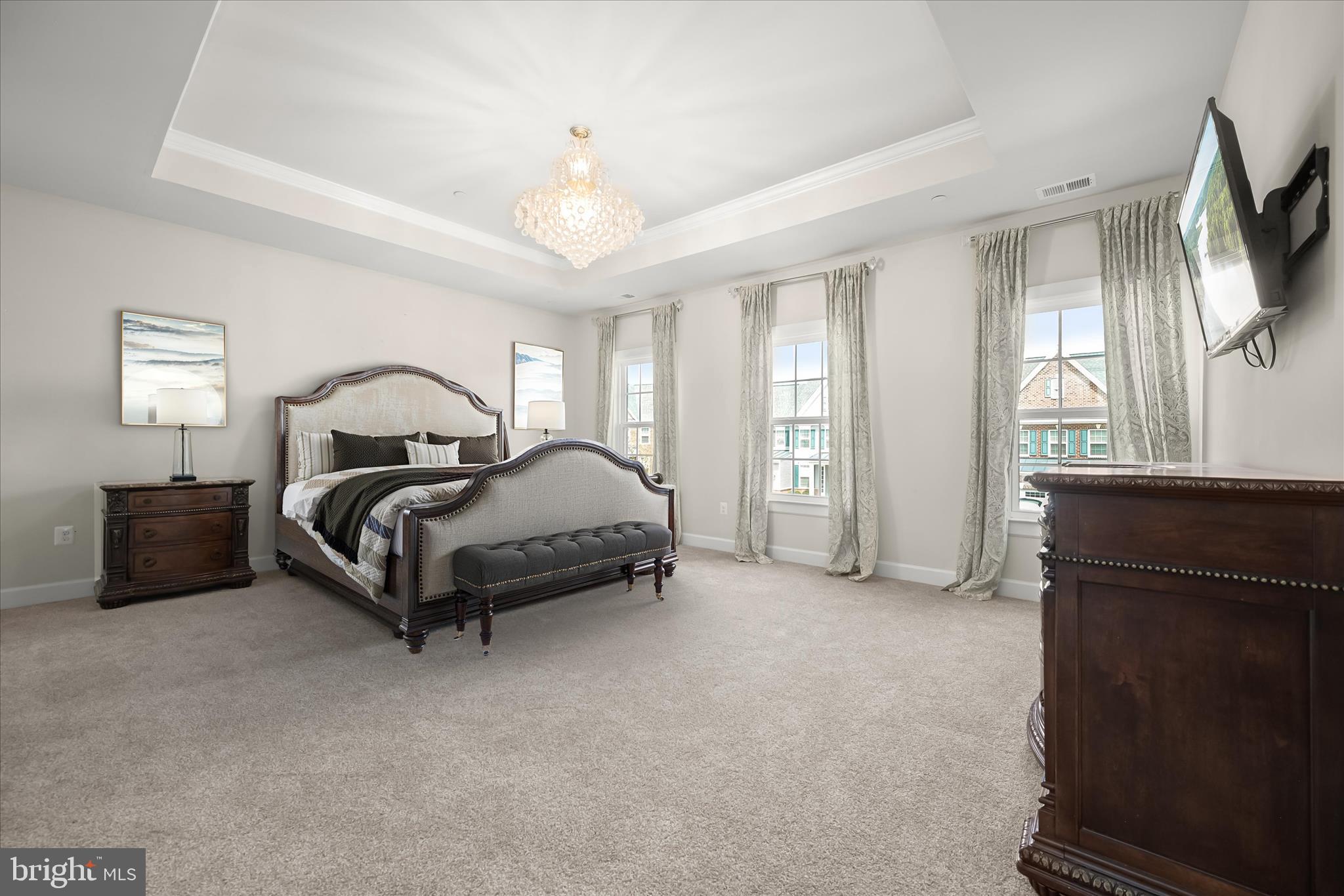 11047 Martha Way Fulton, MD 20759 - Photo 32 of 87 a spacious bedroom with a bed a chandelier and a flat screen television