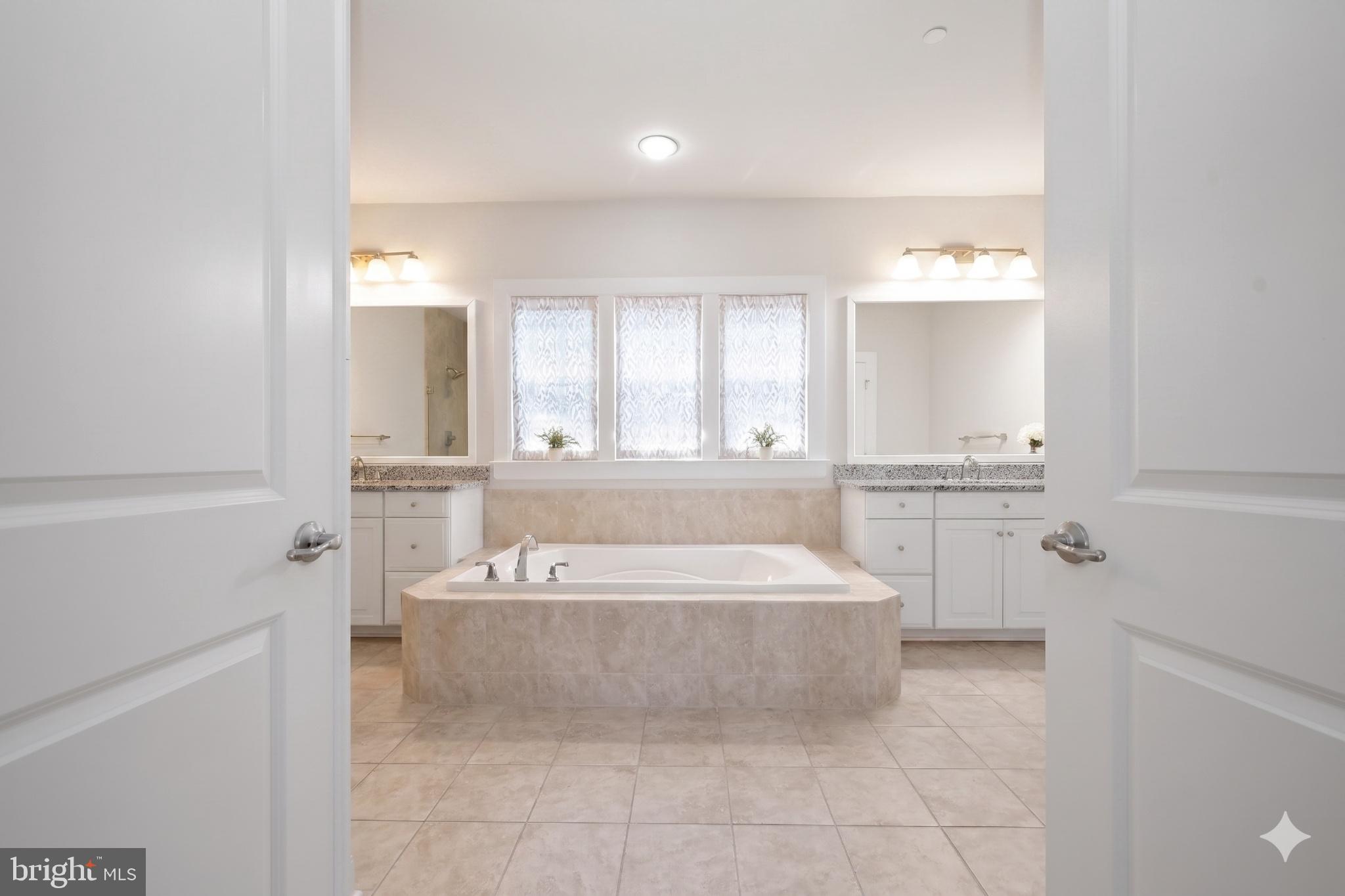 11047 Martha Way Fulton, MD 20759 - Photo 34 of 80 a spacious bathroom with a tub sink and mirror