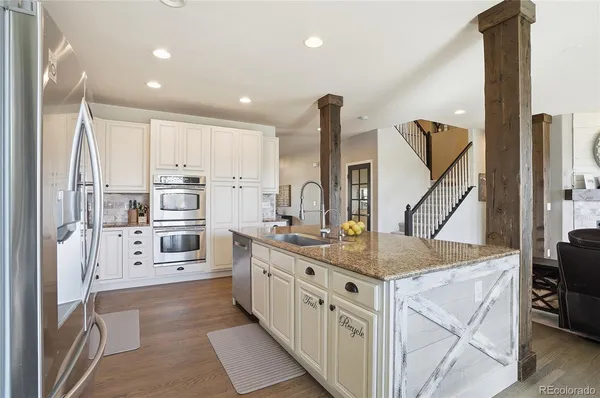 a kitchen with stainless steel appliances kitchen island granite countertop a stove a sink and a refrigerator