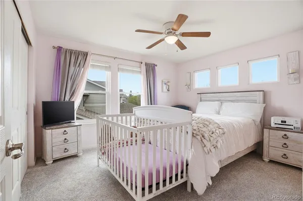 a large bed sitting in a room next to a window and a chandelier