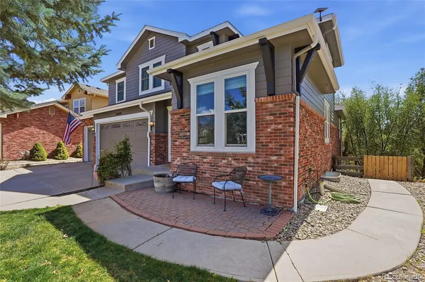 a view of a brick house with a chairs in patio