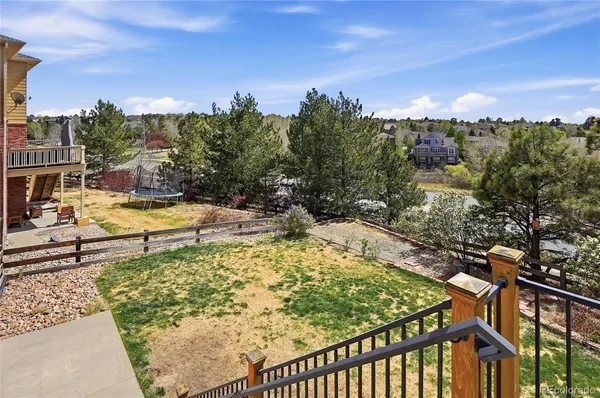 a porch with a table and chairs next to a yard