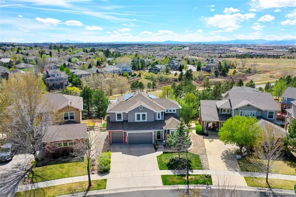 an aerial view of a house with a yard and large trees