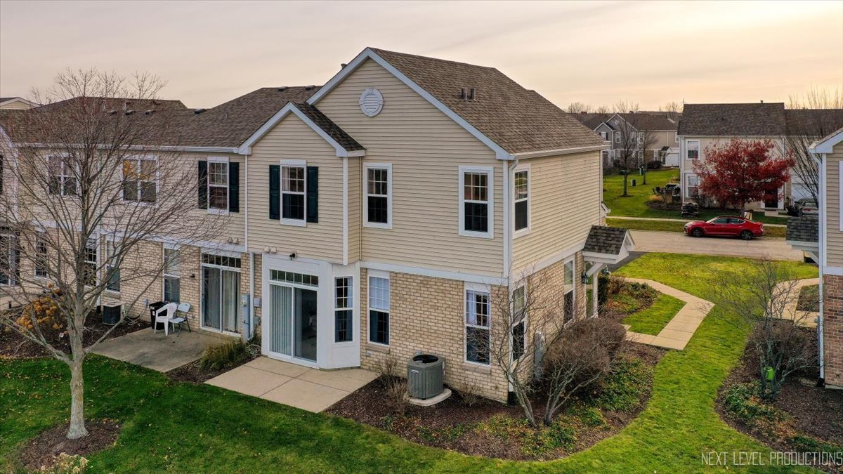 557 Springbrook Trail North Oswego, IL 60543 - Photo 18 of 25 a view of a white house next to a yard with big trees