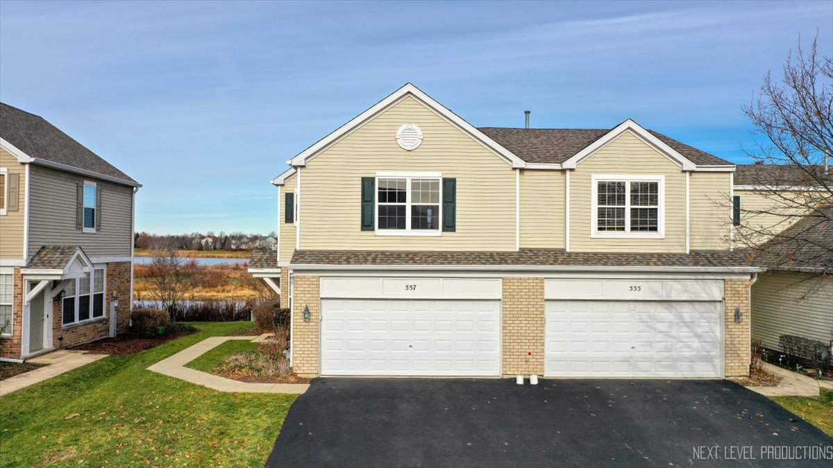 557 Springbrook Trail North Oswego, IL 60543 - Photo 24 of 25 a front view of a house with a yard and garage