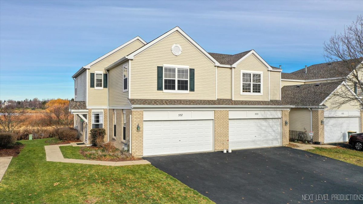 557 Springbrook Trail North Oswego, IL 60543 - Photo 25 of 25 a front view of a house with a yard and garage