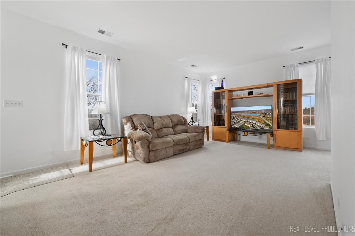 557 Springbrook Trail North Oswego, IL 60543 - Photo 3 of 25 a living room with furniture and a flat screen tv