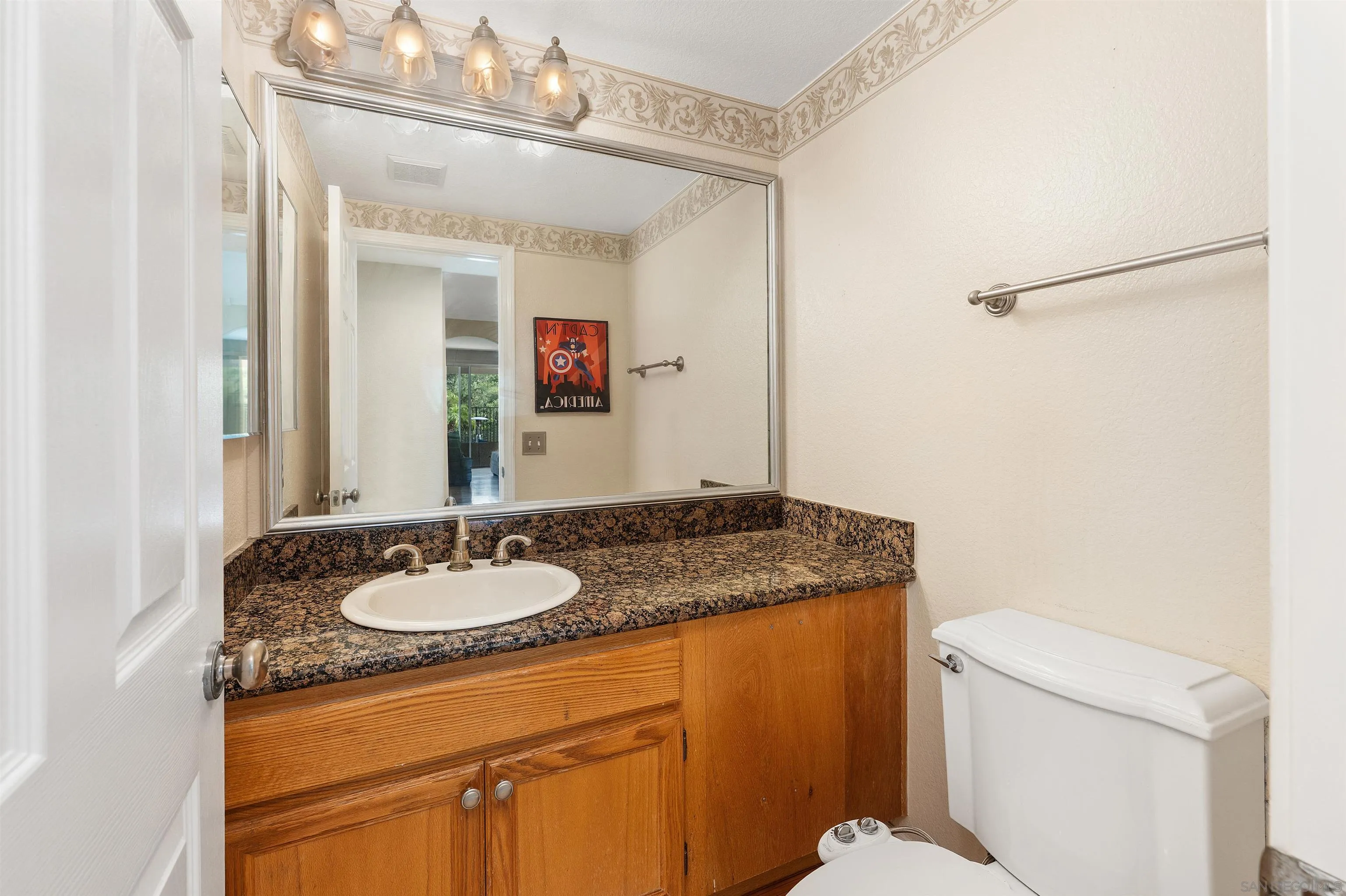 1571 Corte Daniel Oceanside, CA 92056 - Photo 12 of 44 a bathroom with a granite countertop sink and a mirror