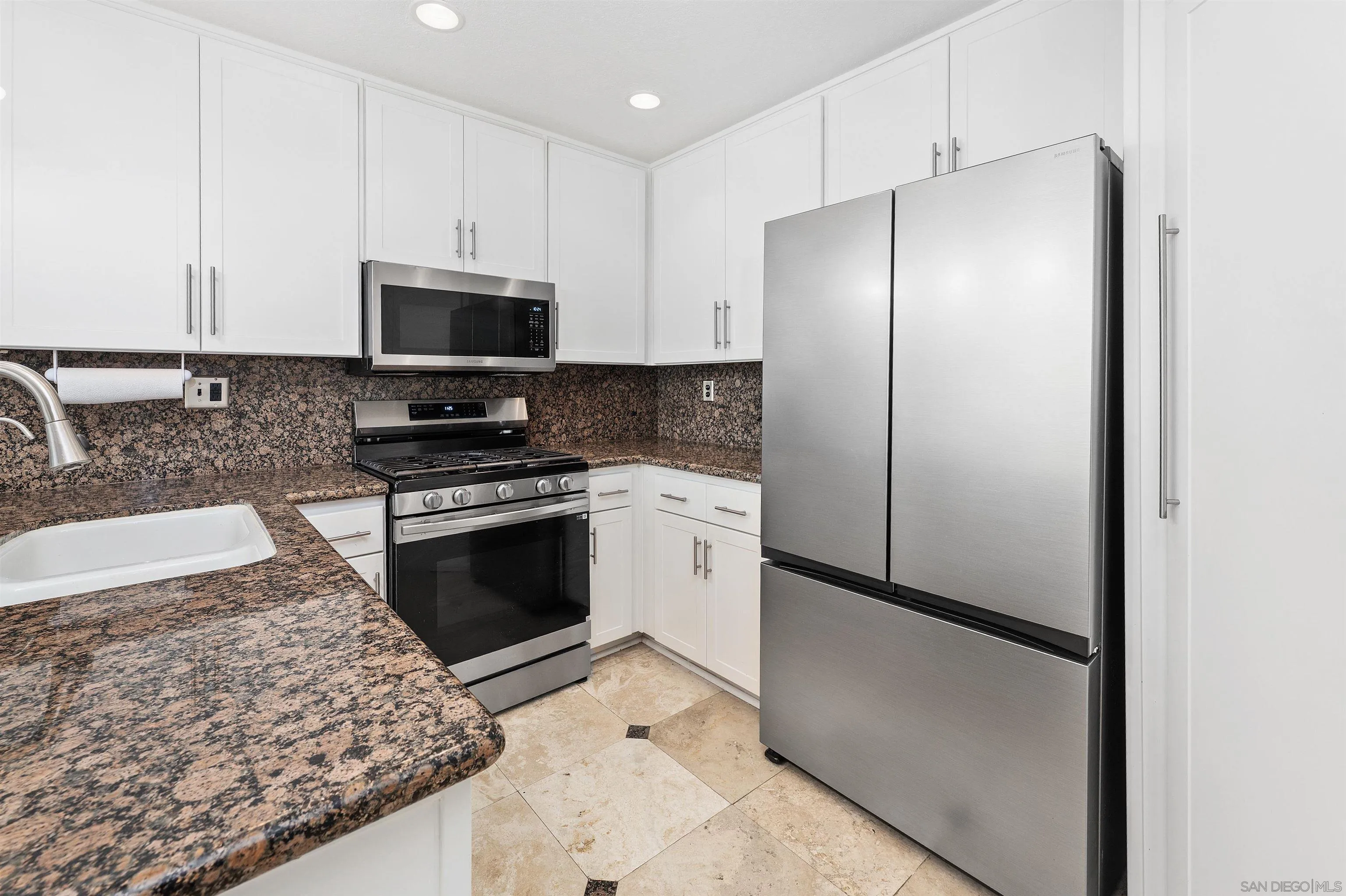 1571 Corte Daniel Oceanside, CA 92056 - Photo 14 of 44 a kitchen with stainless steel appliances granite countertop a refrigerator a stove and a sink