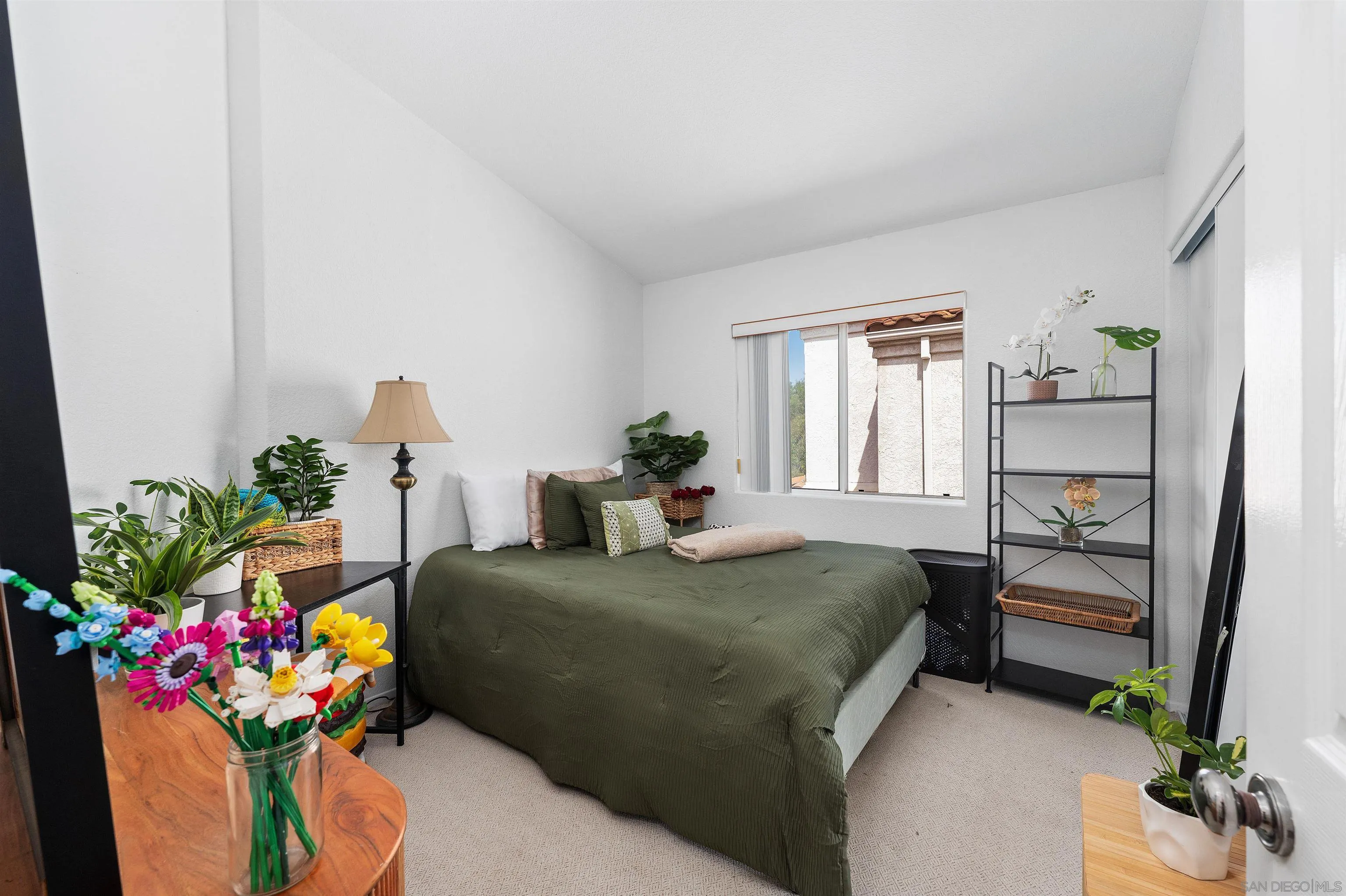 1571 Corte Daniel Oceanside, CA 92056 - Photo 39 of 44 a bedroom with a bed potted plant on the dresser and floor