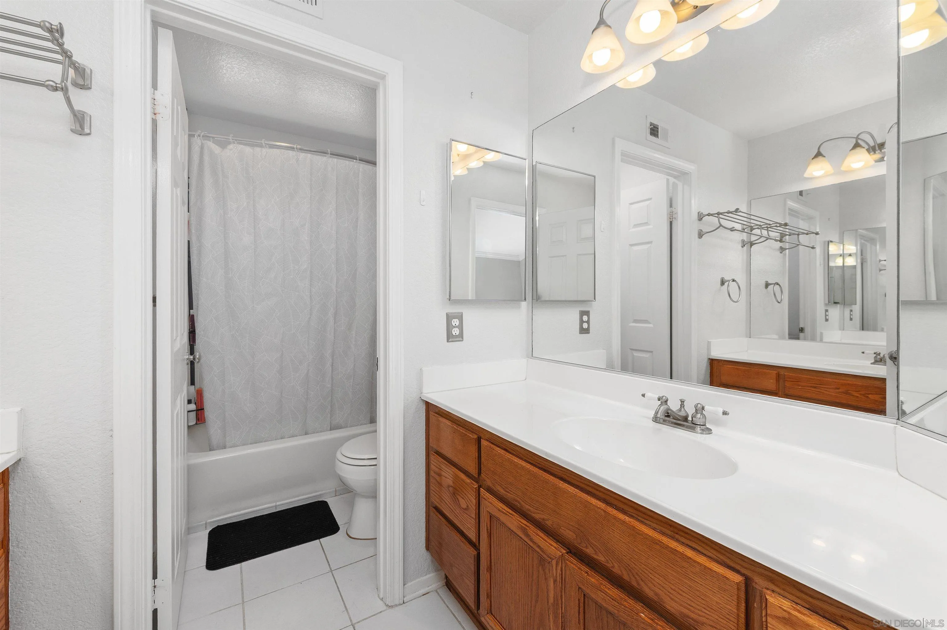 1571 Corte Daniel Oceanside, CA 92056 - Photo 40 of 44 a bathroom with a sink a toilet a shower and a mirror
