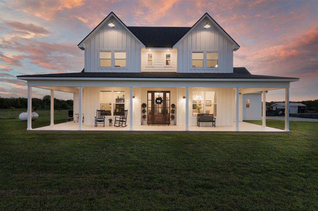 a view of a house with a big yard and large trees