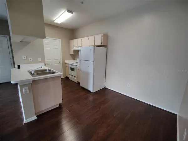 a kitchen with a refrigerator and a stove top oven