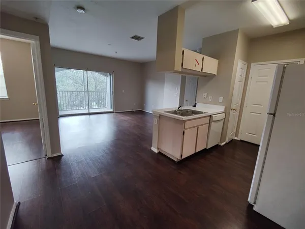 a view of kitchen with wooden floor and electronic appliances