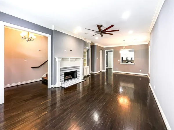 a view of a livingroom with wooden floor a fireplace and windows