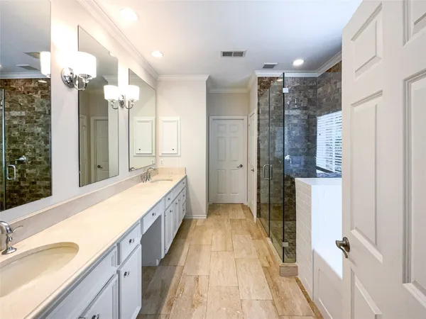 a spacious bathroom with a double vanity sink mirror and shower